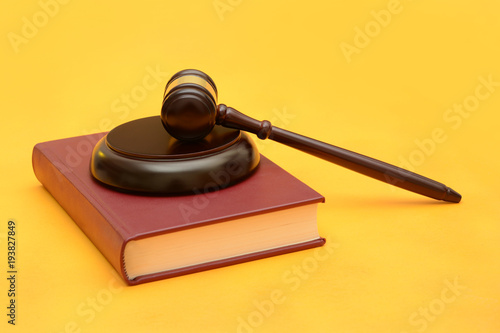 Wood Gavel on law red book yellow background