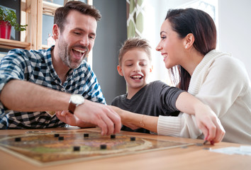 Happy family playing board game at home