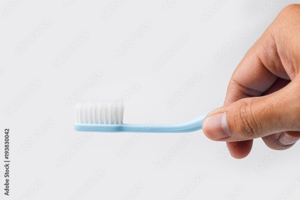 hand holding toothbrush on white background hand holding toothbrush on white background