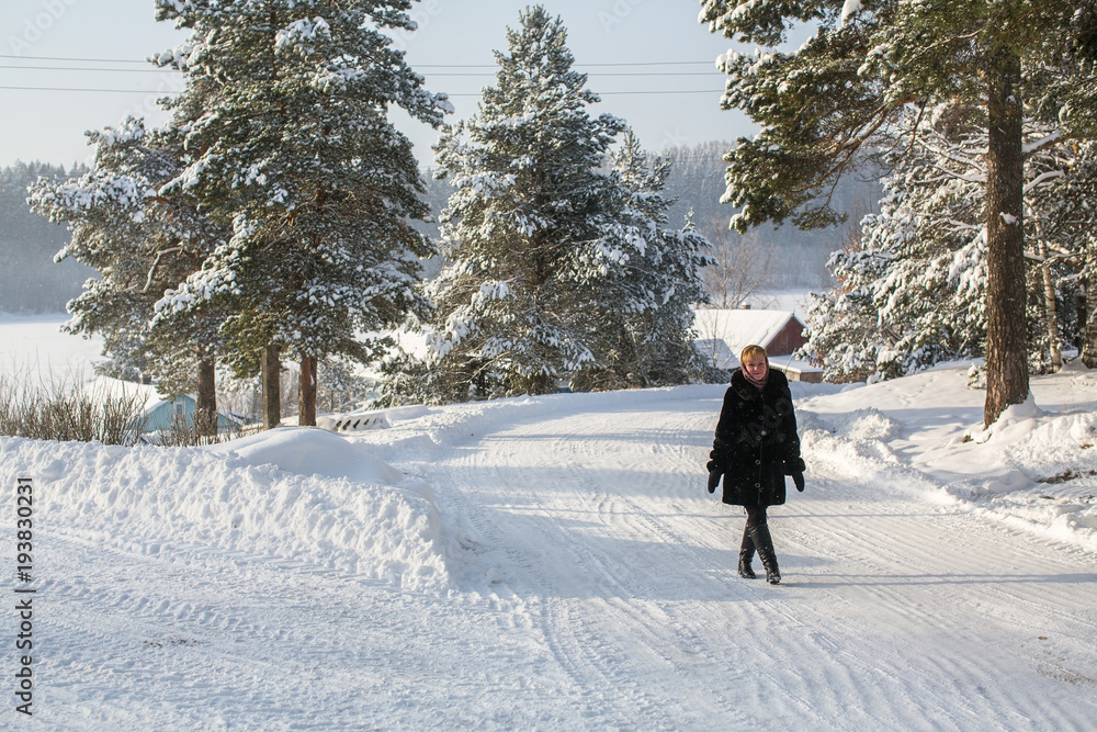 Young woman at winter in the snowy russian village.