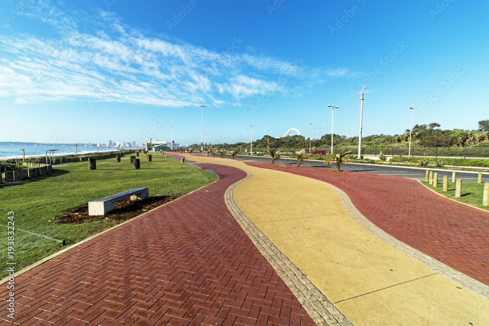 Paved Promenade against Distant  blue cloudy Durban City Skyline