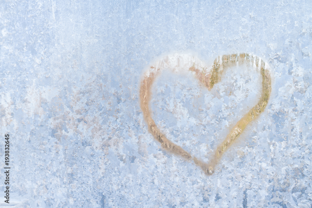 Heart on a frosty winter in the frozen patterns of ice window Heart on a frosty winter in the frozen patterns of ice window