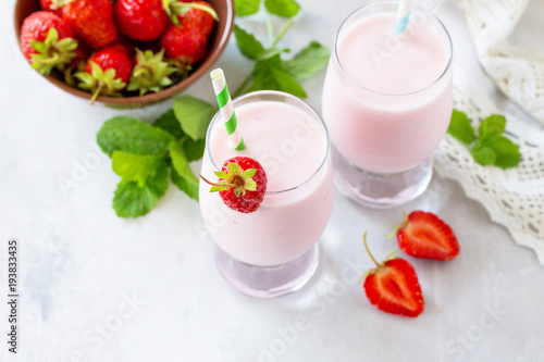 Fresh strawberry smoothie and fresh strawberries on a gray stone or slate background. Vegan dish. Proper nutrition. Healthy lifestyle. Copy space.