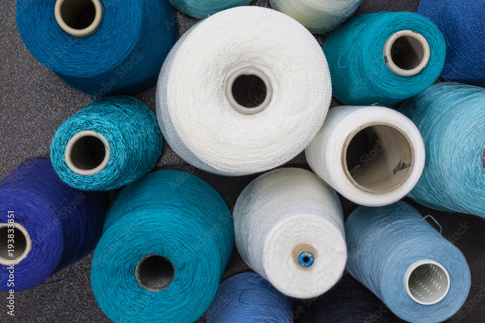 cones of wool and cotton yarn in white, turquois, blue and green cones of wool and cotton yarn in white, turquois, blue and green