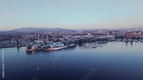 Aerial clockwise tripod shot at sunset of Aker Brygge and City Hall in Oslo, Norway seen from fjord photo