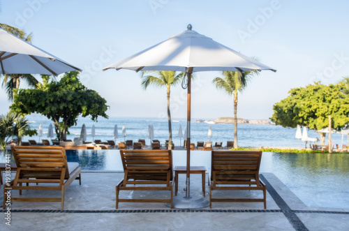 Chairs and Umbrella Poolside with a View of the Ocean at a Beautiful Mexican Resort