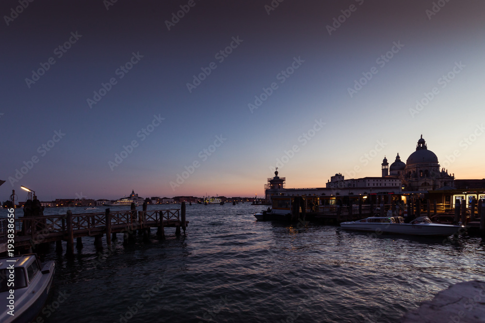 VENICE, ITALY - FEBRUARY 10 2018: vaporetto terminal  at sunset in front of Basilica della Salute. The vaporetto is the public means par excellence of the city