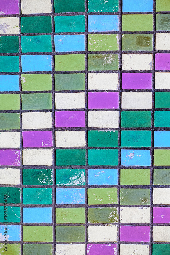 texture of old wall tiles with peeling bright paint. colorful old shabby tiles
