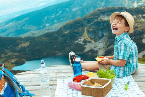 Little boy on a picnic in the mountains photo