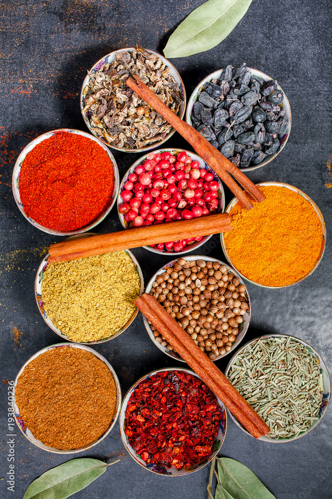 Fototapeta premium Spices and herbs. Variety of spices and mediterranean herbs on black stone