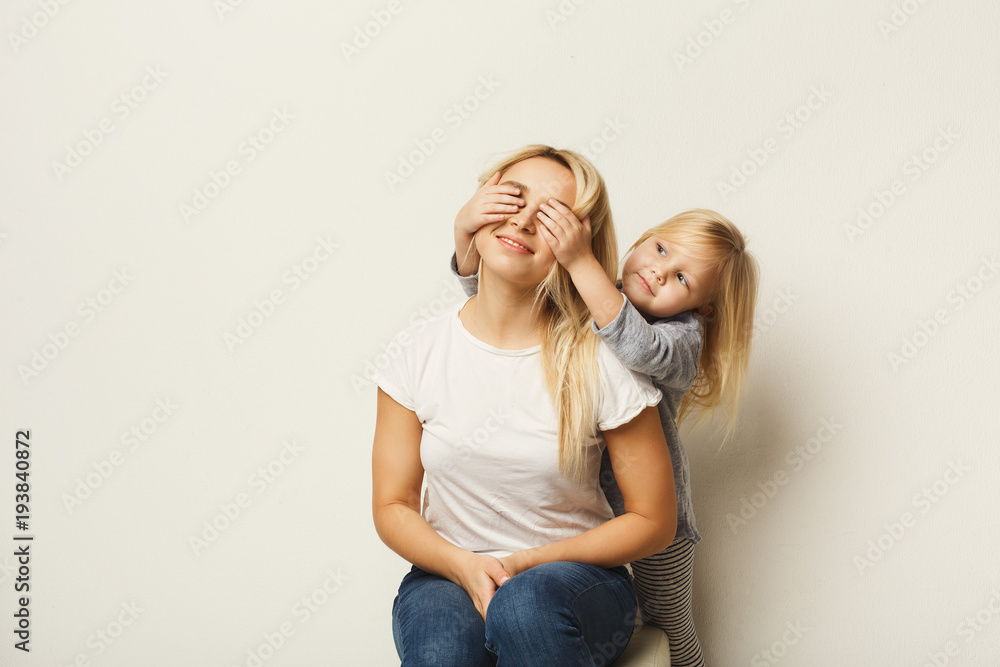 Happy mother and daughter embracing at white studio background Happy mother and daughter embracing at white studio background