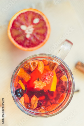 Tea made from dried fruit, seasoned with cinnamon cloves and anise seeds. There is an orange nearby