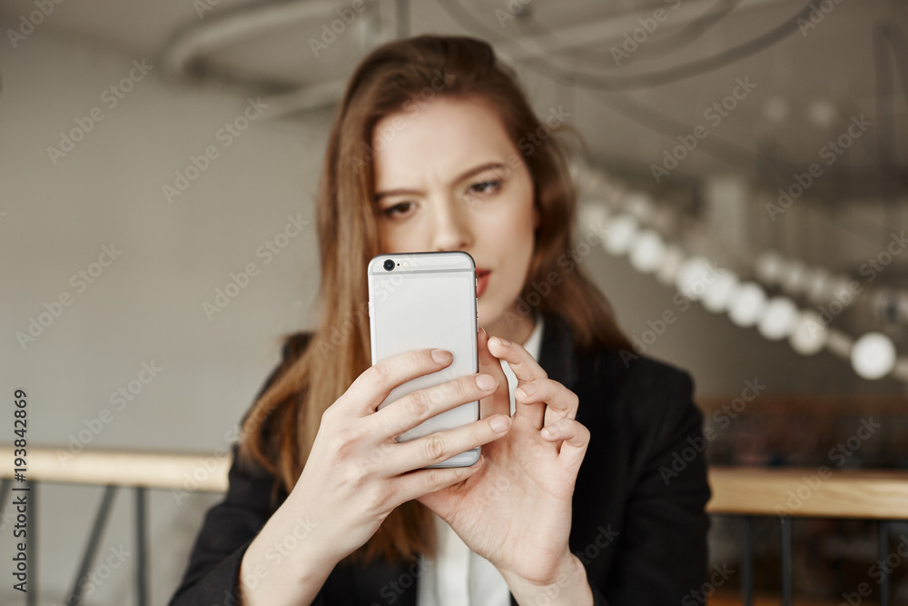 I still did not figured out how this smartphone works. Indoor shot of good-looking adult woman in modern outfit holding smartphone, focusing on screen while searching information in internet I still did not figured out how this smartphone works. Indoor shot of good-looking adult woman in modern outfit holding smartphone, focusing on screen while searching information in internet