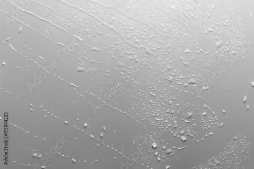 Surface with water drops, grey background.