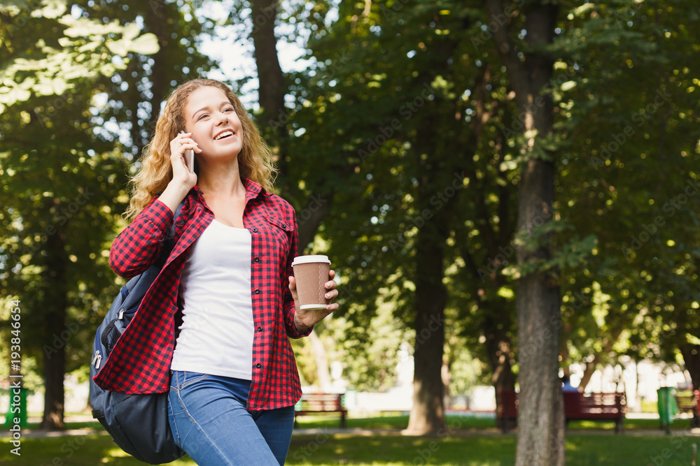 Beautiful female student talking on mobile phone outdoors Beautiful female student talking on mobile phone outdoors