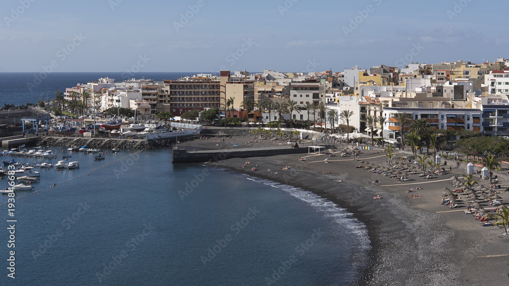 Vantage views towards the harbor, town and the small beach of black sand, lapilli and pebbles, populated all year round