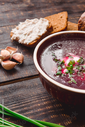 soup with onions and slices of bread on a dark wooden background