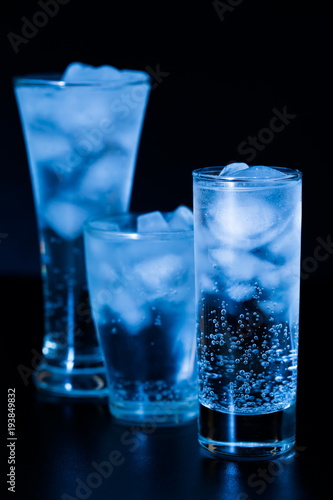 Drink. Water glass and ice, dark background