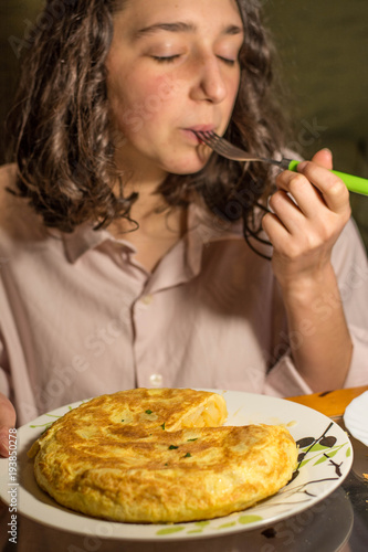 Girl eating Spanish omelette