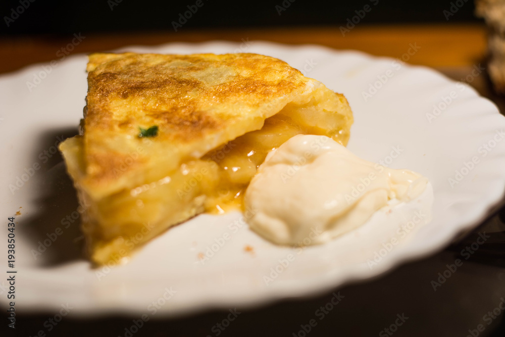Piece of spanish omelette in a white plat