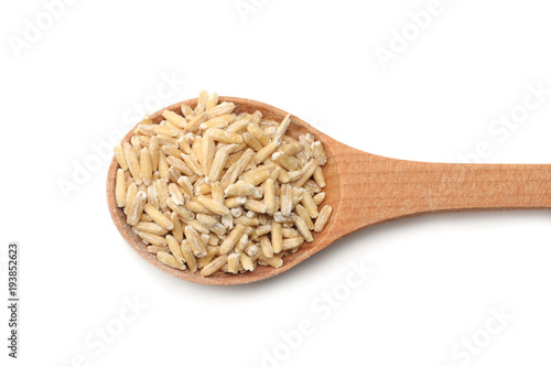 oat grains in wooden spoon isolated on white background top view