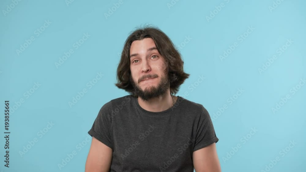 Portrait of young guy 25s acting like drunk addicted man having deviant behaviour while celebrating on party, isolated over blue background. Concept of emotions Portrait of young guy 25s acting like drunk addicted man having deviant behaviour while celebrating on party, isolated over blue background. Concept of emotions