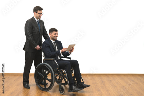 Valokuva The happy businessman and the invalid hold a tablet on the white wall background