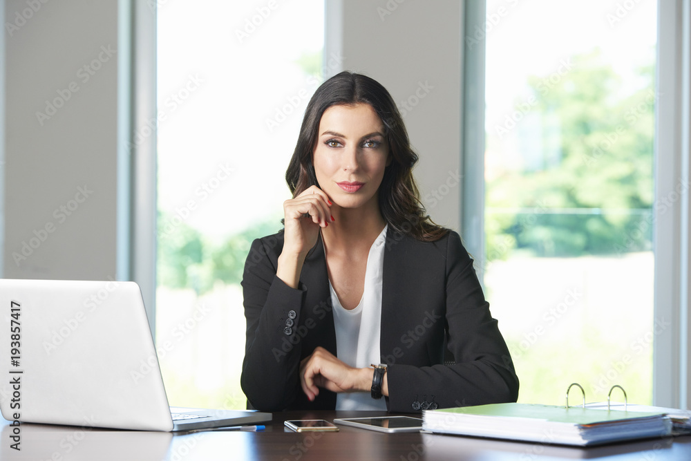 Thinking young businesswoman in the office.Shot of a beautiful young business woman sitting at office desk and using laptop while working. Thinking young businesswoman in the office.Shot of a beautiful young business woman sitting at office desk and using laptop while working.