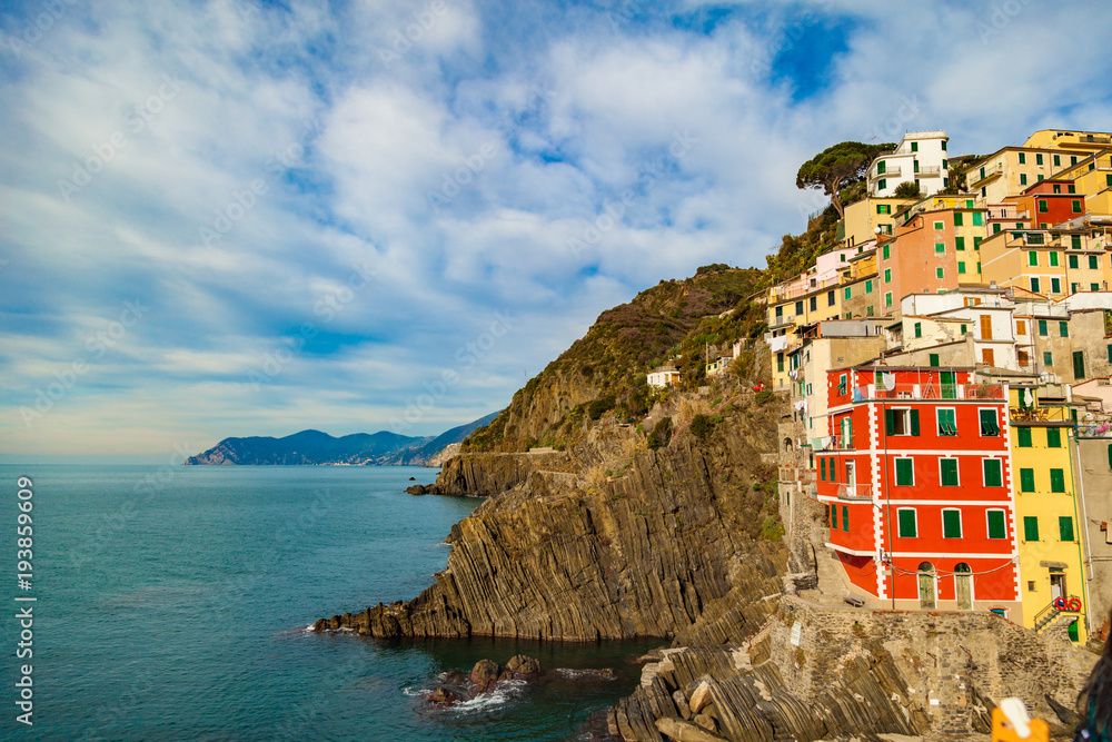 View of the colorful houses and coastline from Riomaggiore centre. Riomaggiore is one of the five famous Cinque Terre villages.