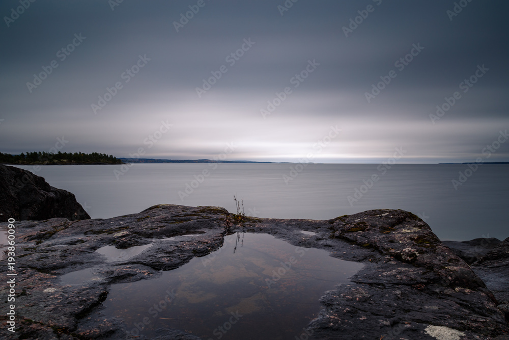 Long exposure of sea landscape with a rock in the foreground