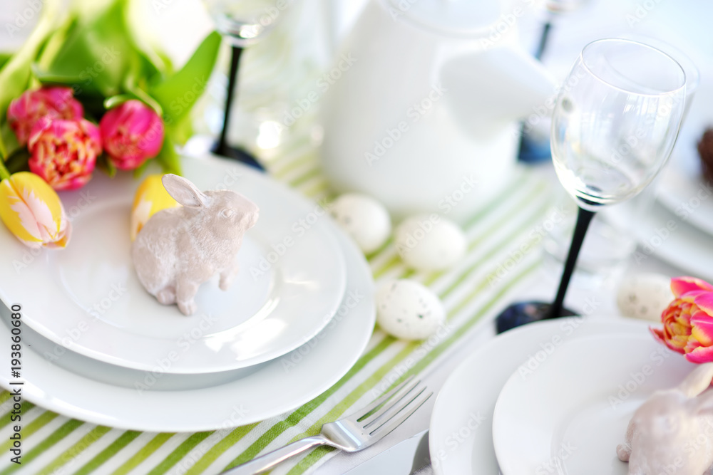 Beautiful table setting with crockery and flowers for Easter celebration Beautiful table setting with crockery and flowers for Easter celebration