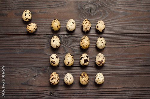 Quail eggs on dark wooden background. The view from the top. Copy spaсe