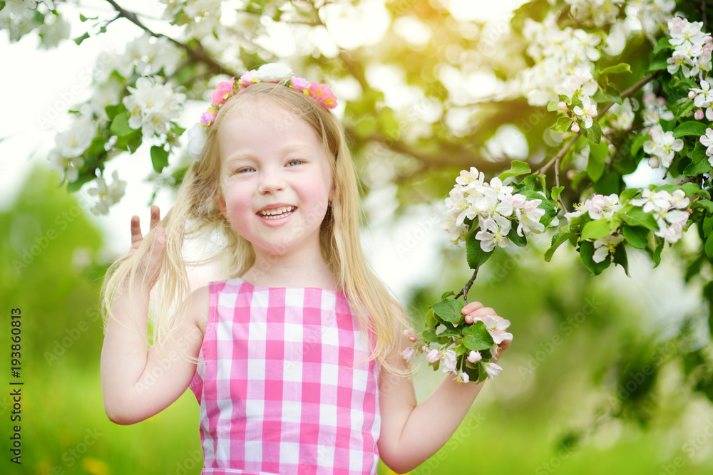 Adorable little girl in blooming apple tree garden on beautiful spring day Adorable little girl in blooming apple tree garden on beautiful spring day
