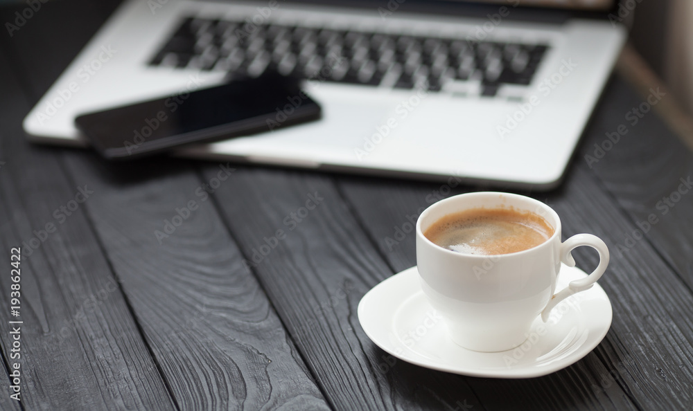 Coffee Cup on the white table on blurred laptop background for Business Concept. Coffee Cup on the white table on blurred laptop background for Business Concept.