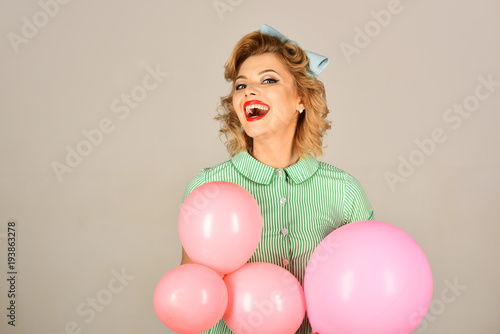 beautiful pin-up retro woman playing with pink balloons