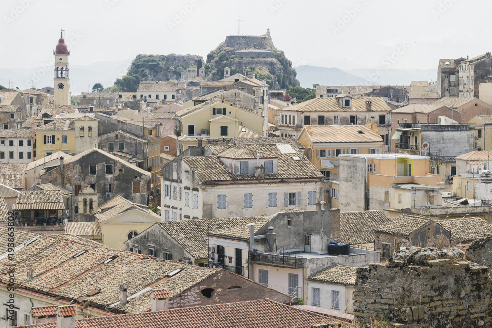 View on Old Fortress of Corfu city or Kerkyra from New Fortress. Skyline of typical houses of old town. Tourist attraction and popular vacation destination. Sunny day in beginning of June. 