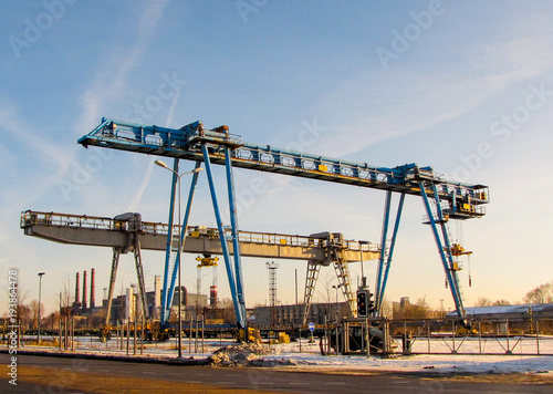 Two bridge crane against a blue sky