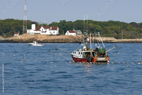 Картината върху платно Fishing Trawler Coming Home By Eastern Point Lighthouse in Gloucester, Massachus
