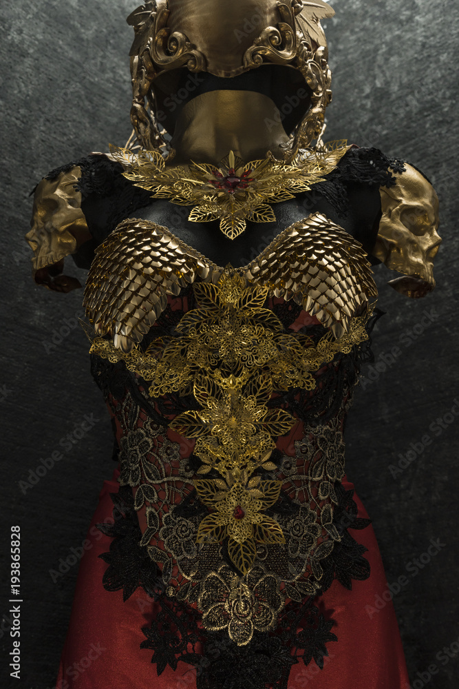 and metal pieces handmade, it has a golden breastplate of dragon scales with a helmet of gothic pieces and red feathers Stock Photo | Adobe Stock