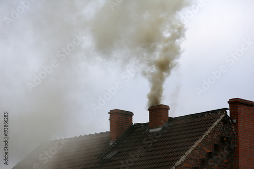 Brown smoke from chimney house due to combustion of coal Fototapet