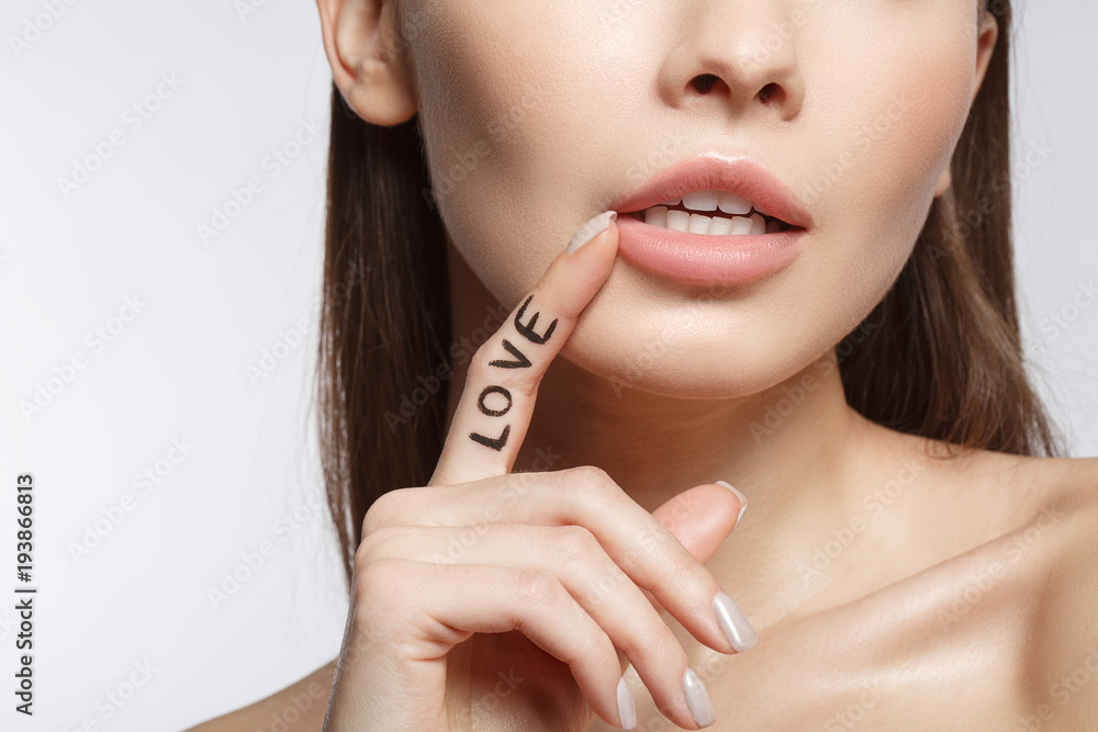 Close up of affectionate young woman touching her lips with desire. Love concept. Isolated and copy space Close up of affectionate young woman touching her lips with desire. Love concept. Isolated and copy space