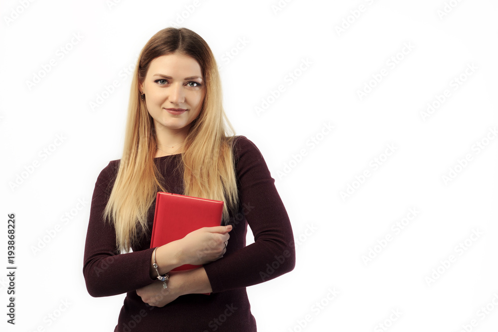 Young charming girl in sweater holding book and tablet and smiling at camera. Young charming girl in sweater holding book and tablet and smiling at camera.