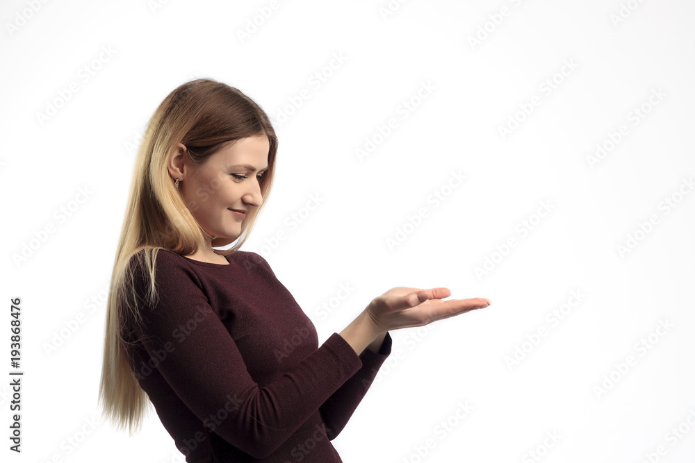 Girl shows a hand advertising. Woman with outstretched hand. Beautiful girl. Beautiful portrait of a girl over a white background. Space for text Girl shows a hand advertising. Woman with outstretched hand. Beautiful girl. Beautiful portrait of a girl over a white background. Space for text