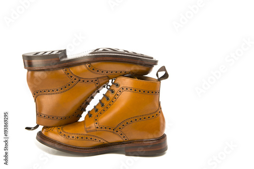 Footwear Ideas. Premium Tanned Brogue Derby Boots Made of Calf Leather with Rubber Sole. Turned Over Each Other. Isolated Over Pure White Background.