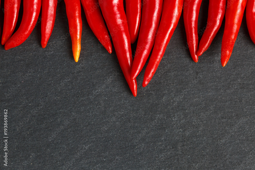 Slate background with red hot chilli peppers. Slate background with red hot chilli peppers.