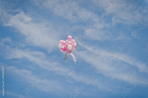 A group of white and pink balloons flying into the sky 684.