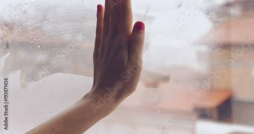 Hand Wiping Out Heart Painted On Steamed Window In A Rainy Day Closeup