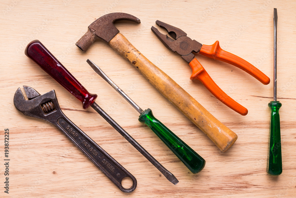 Screwdrivers, hammer, pliers and tools on a wooden table Screwdrivers, hammer, pliers and tools on a wooden table