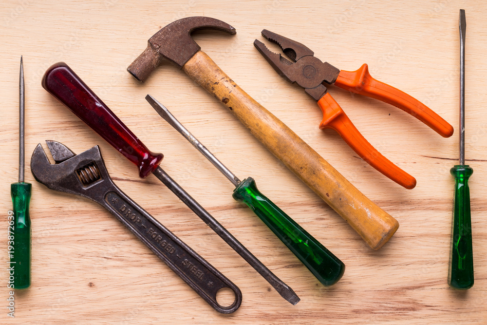 Screwdrivers, hammer, pliers and tools on a wooden table Screwdrivers, hammer, pliers and tools on a wooden table