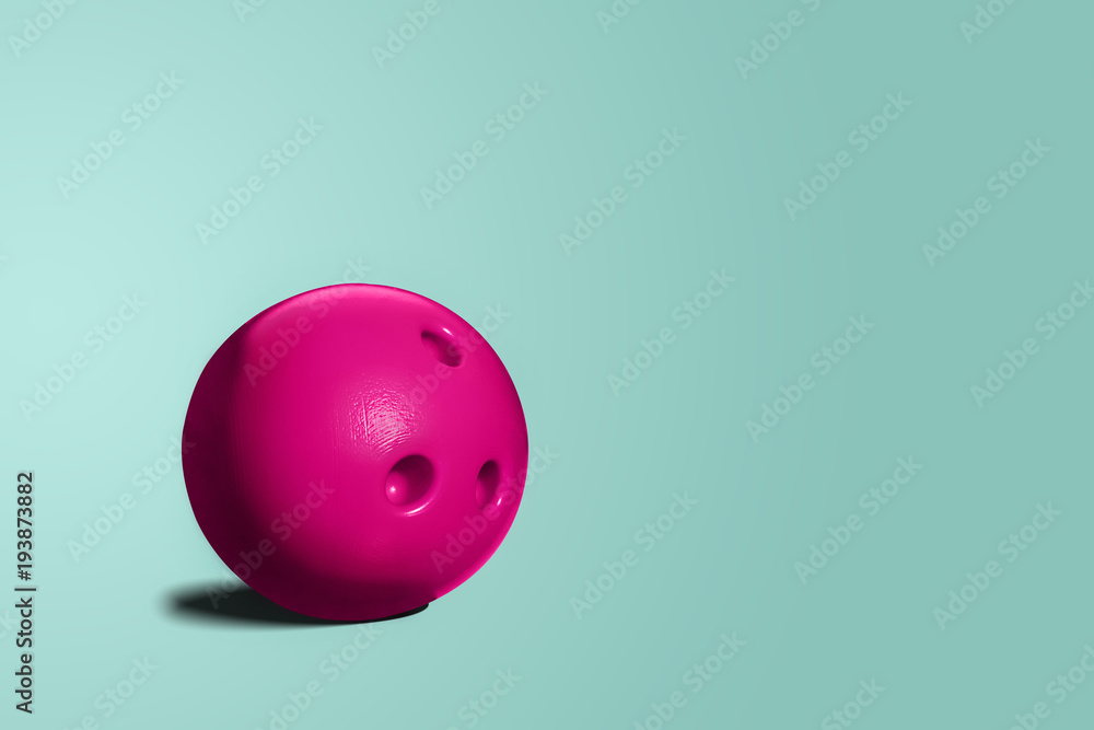 Pink bowling ball. A toy bowling ball of pink color on a blue